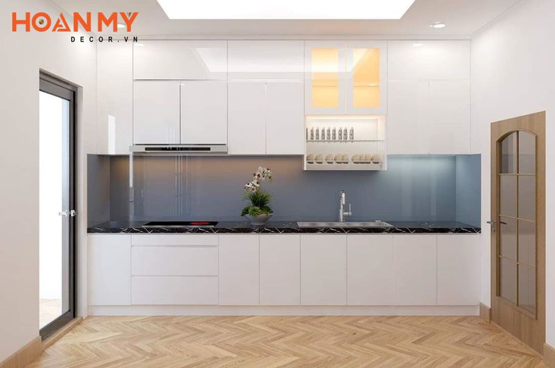 Tủ bếp chất liệu acrylic tông màu trắng nổi bật với đá ốp tường màu xanh
