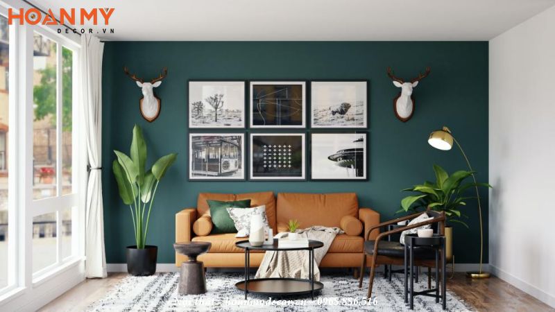 Sơn tường màu xanh kết hợp sofa màu cam và tranh treo tường ấn tượng