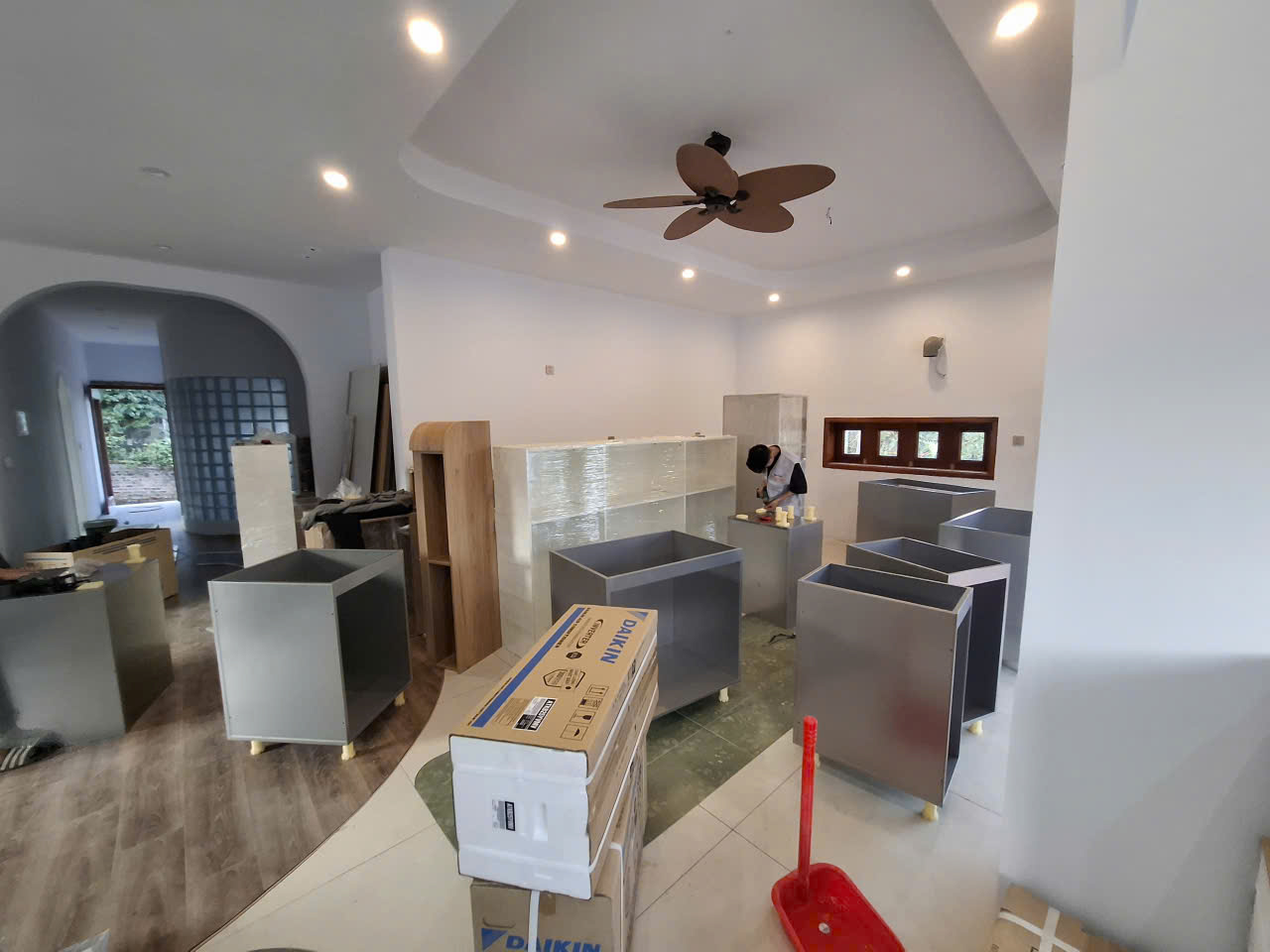Các thùng tủ màu ghi và cấu kiện bọc màng được tập kết trong phòng để lắp đặt.