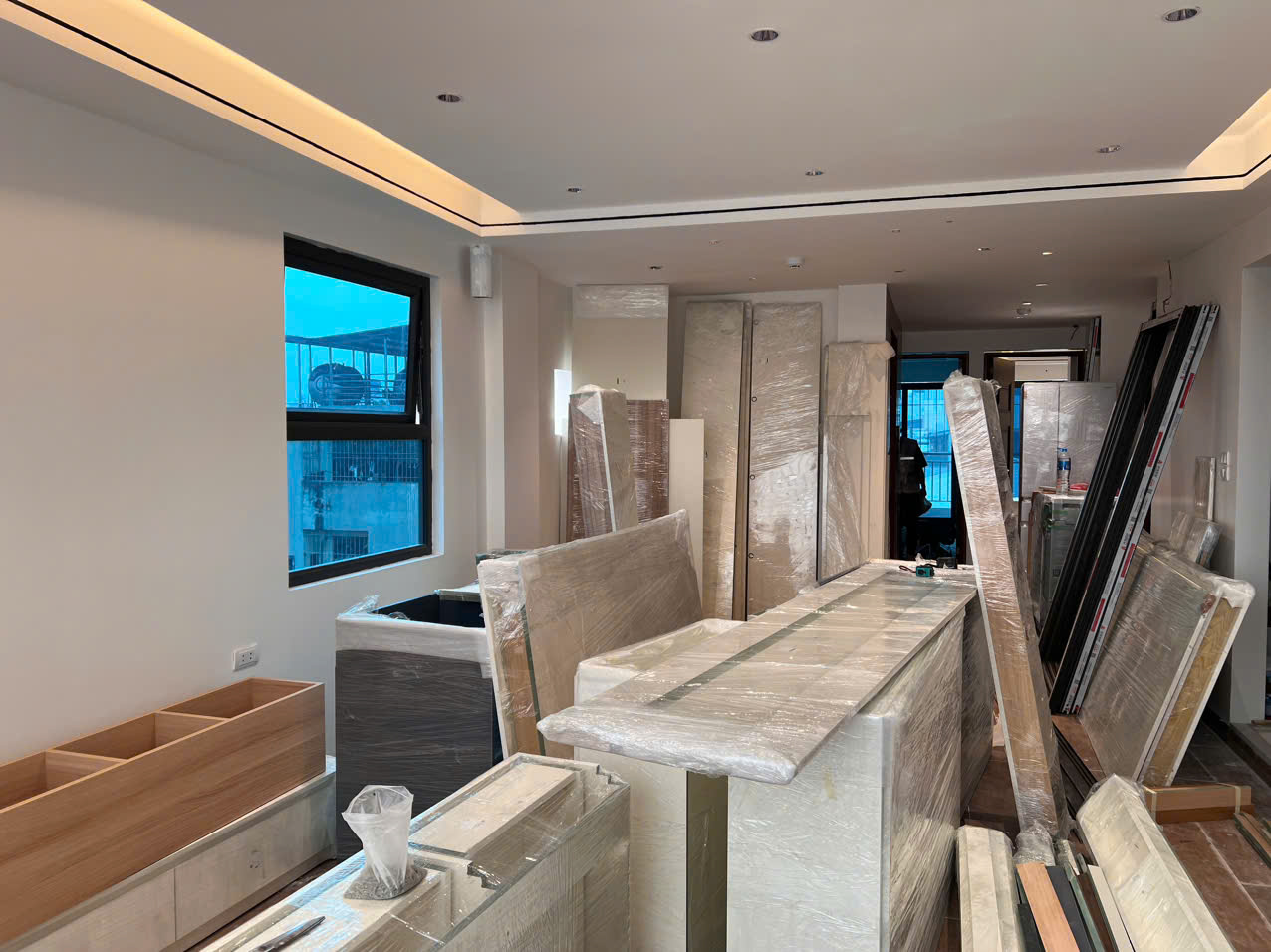 Các cấu kiện tủ, vách và tấm nội thất được bọc bảo vệ, tập kết trong phòng trước khi lắp.