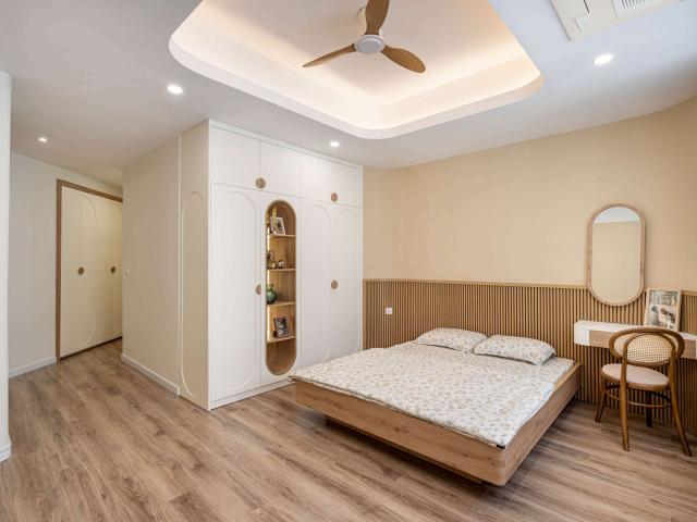 Phòng ngủ sáng với giường vân gỗ và tủ trắng hốc vòm