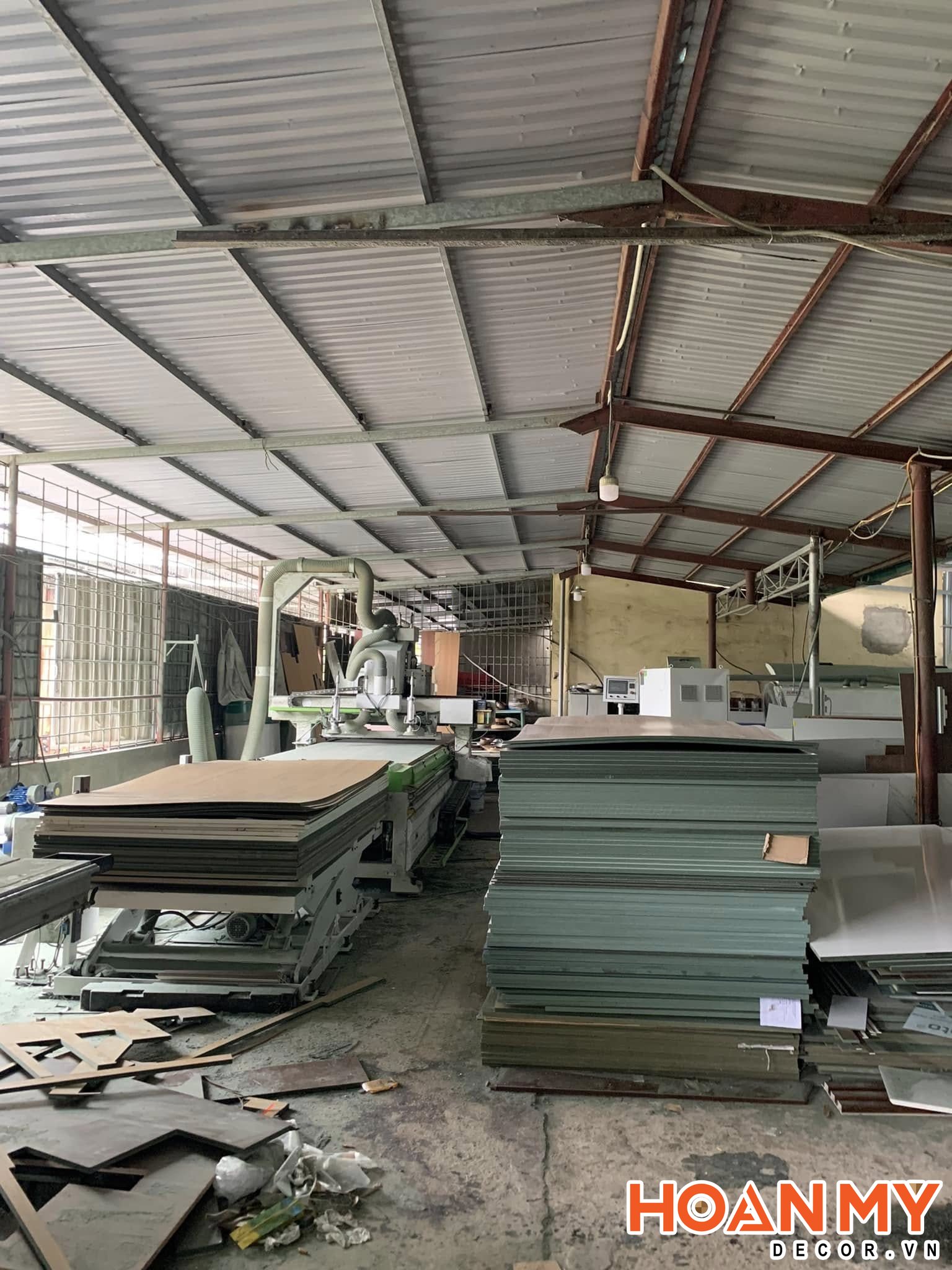 Bên trong xưởng Hoàn Mỹ Decor, các chồng ván MDF lõi xanh được tập kết ngay cạnh máy CNC để đưa vào cắt.