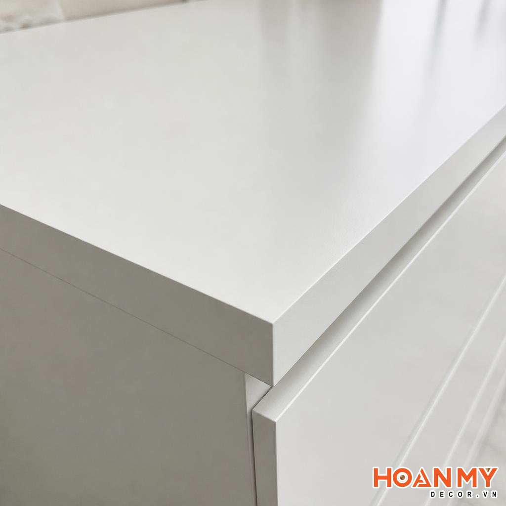Cận cảnh bề mặt tủ gỗ MDF sơn Inchem bệt màu trắng, góc chụp nghiêng 45 độ lộ rõ độ phẳng mịn của lớp sơn